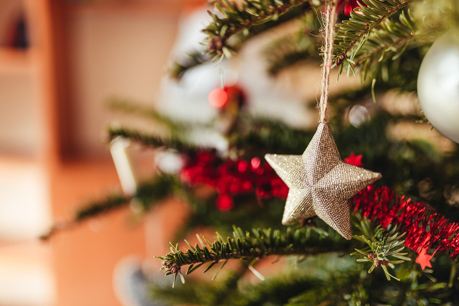 selective-focus-shot-star-ornament-hanging-christmas-tree
